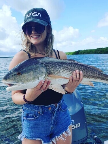Woman holding a fish they caught in Tampa Bay