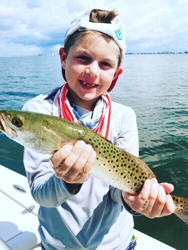 Child holding a fish they caught in Tampa Bay