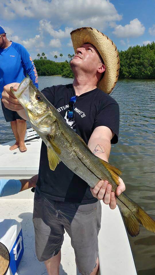 Gentleman holding a fish on a boat in Tampa Bay Florida