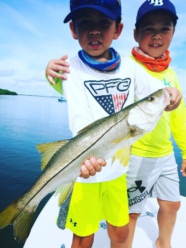 Children holding a fish that was caught in Tampa Bay