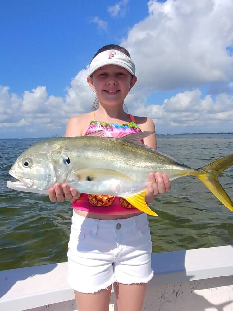Child on a boat holding a fish they caught