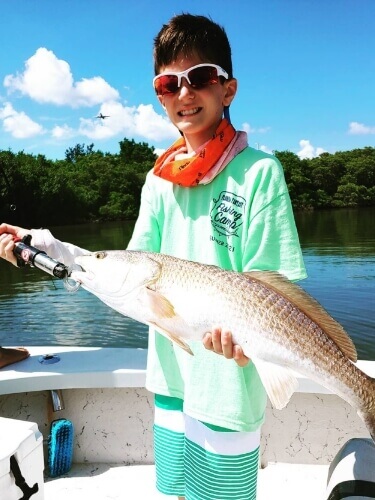 Child holding a fish caught in Tampa Bay