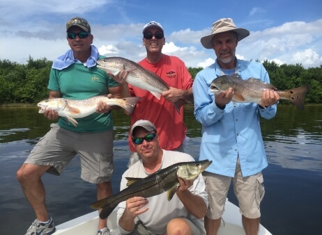 Group of gentlemen each holding a fish that was caught in Tampa Bay