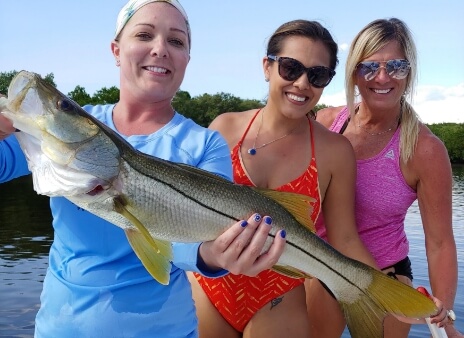 Group of women holding a fish that was caught in Tampa Bay