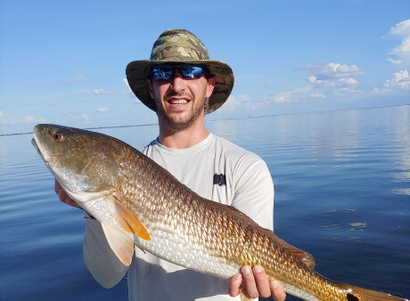 Person holding an orange fish that was caught in Tampa Bay